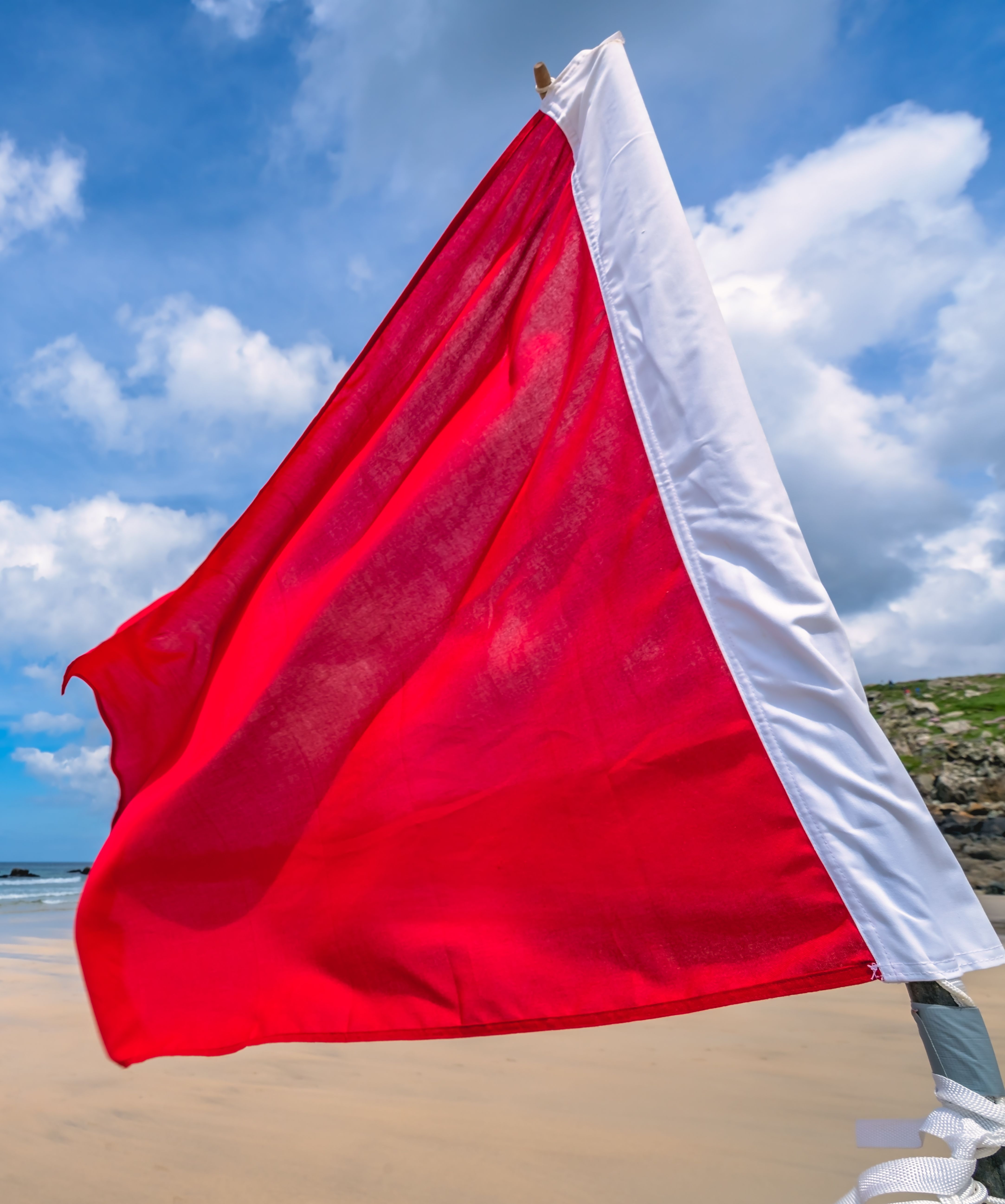 red lifeguard flag on beach