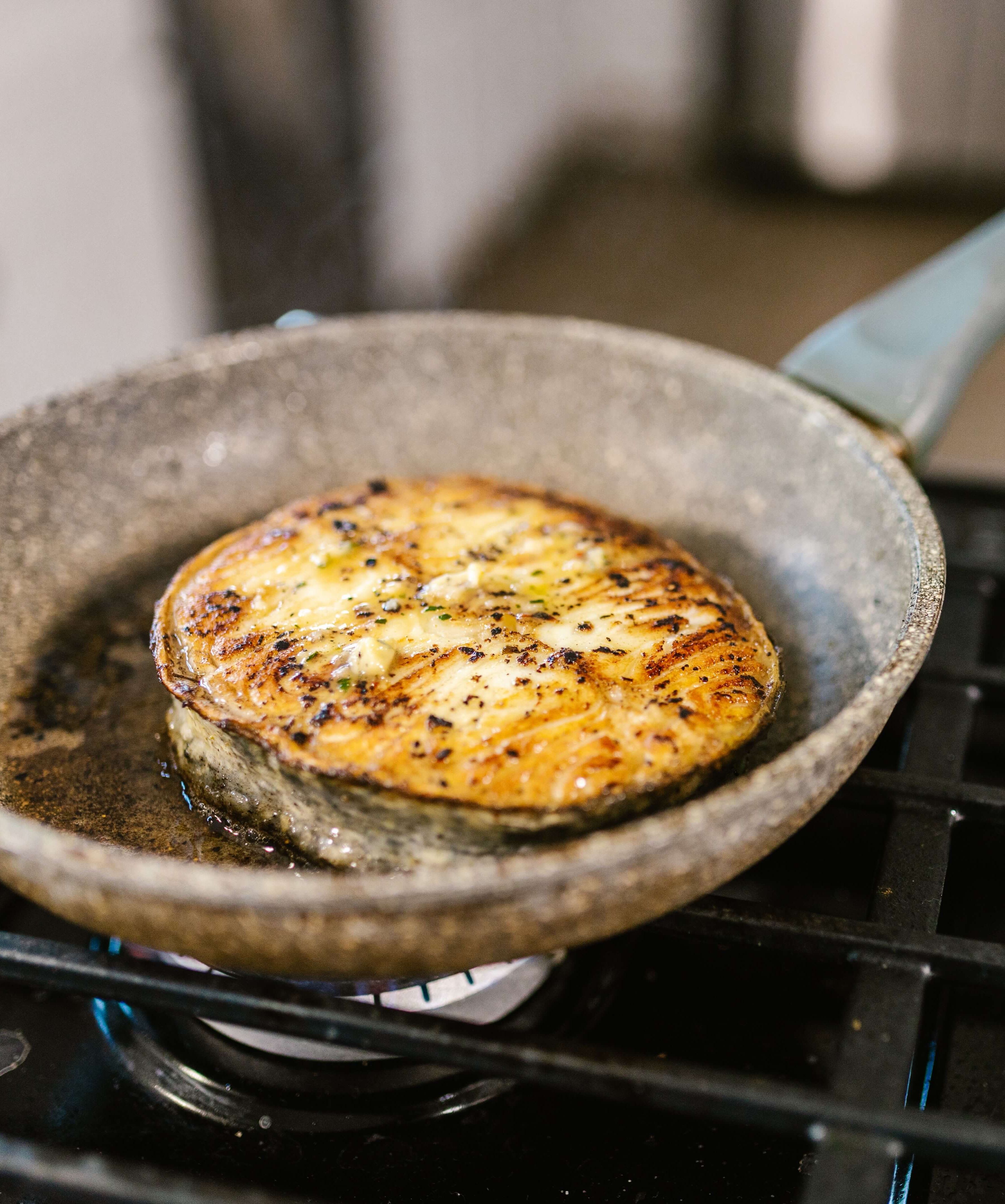 Fish cooking in frying pan