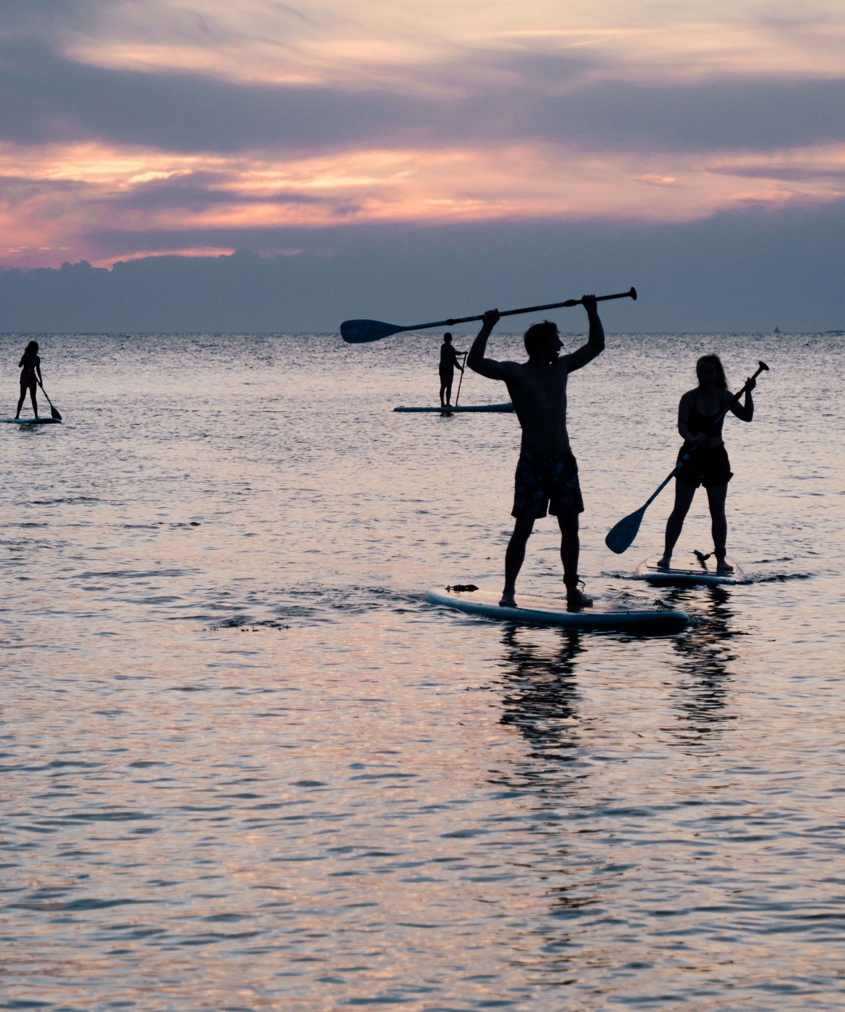 People paddle boarding on sea
