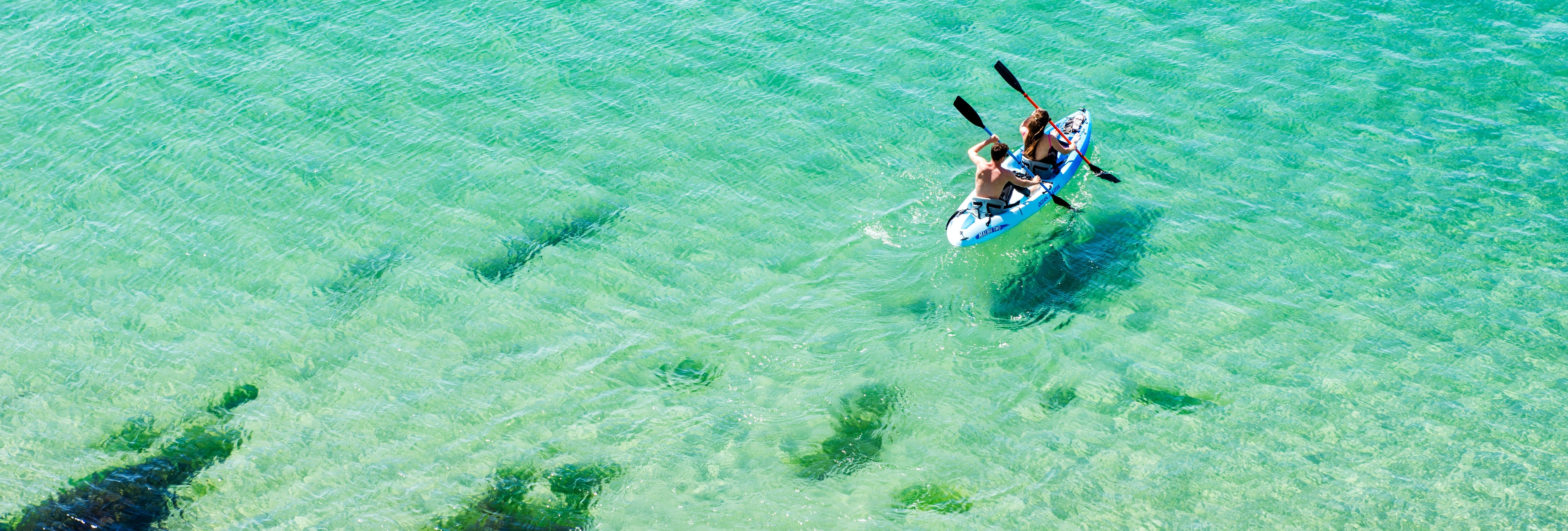 People kayaking on clear turquoise sea