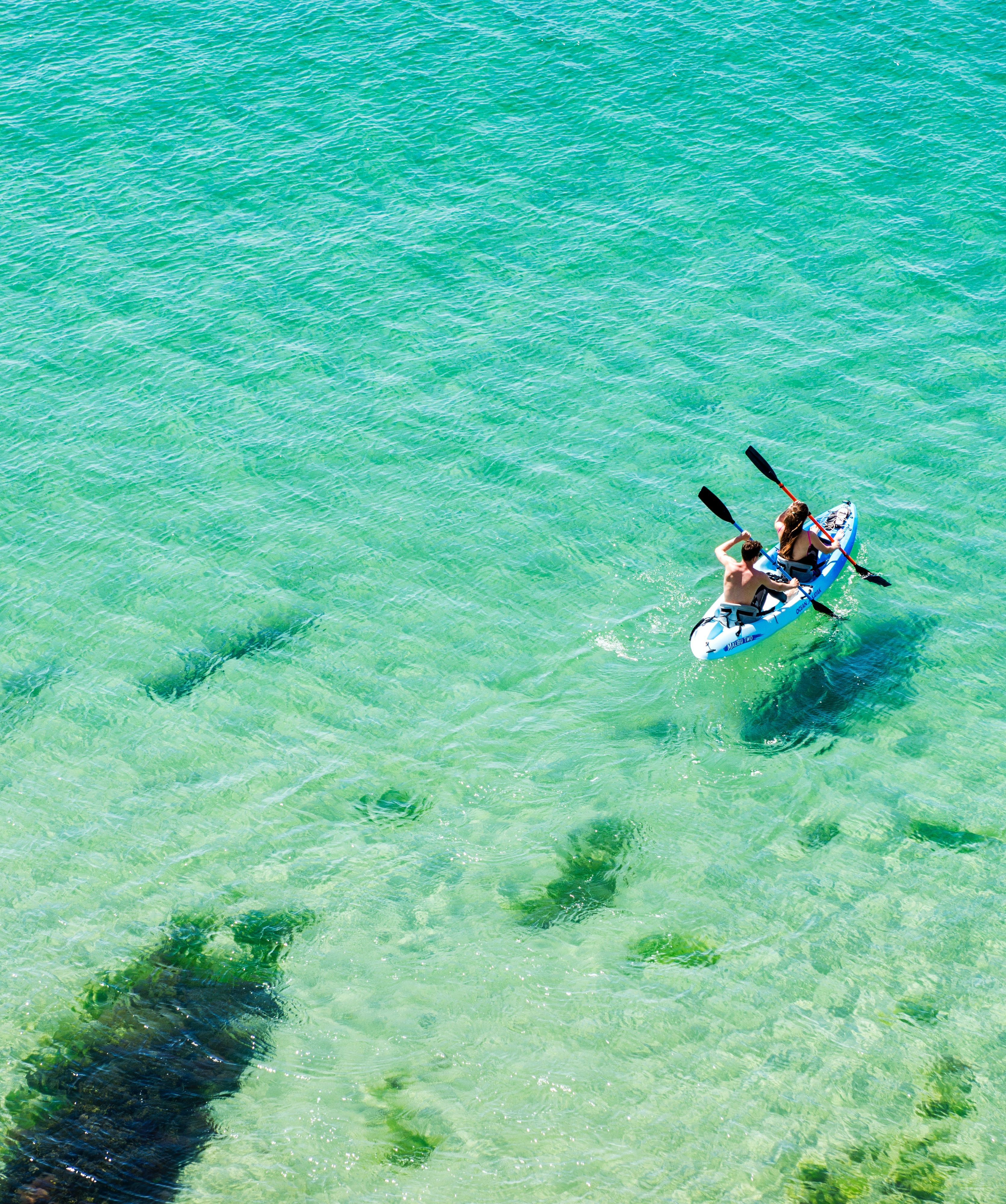 People kayaking on clear turquoise sea