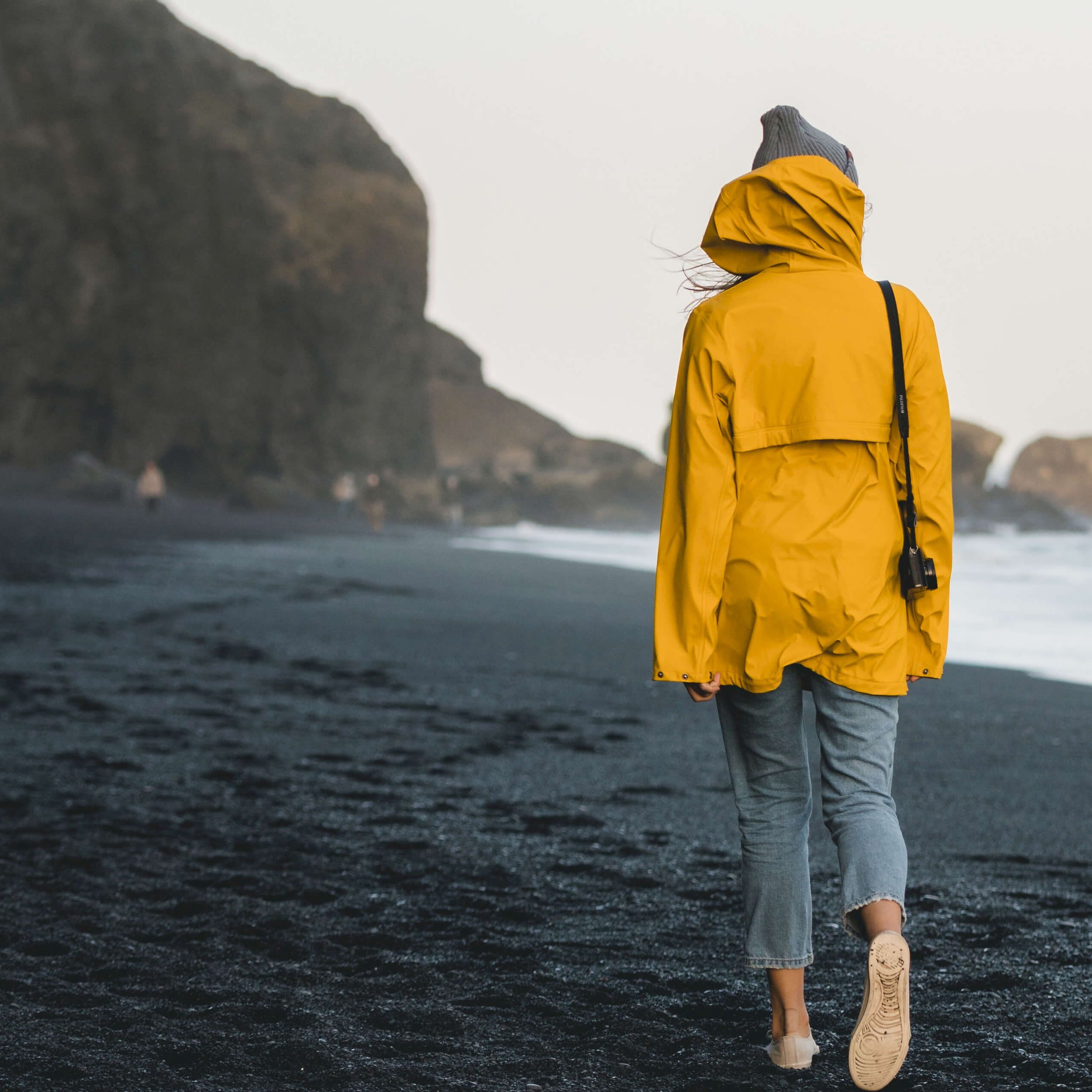 Woman in yellow coat on beach