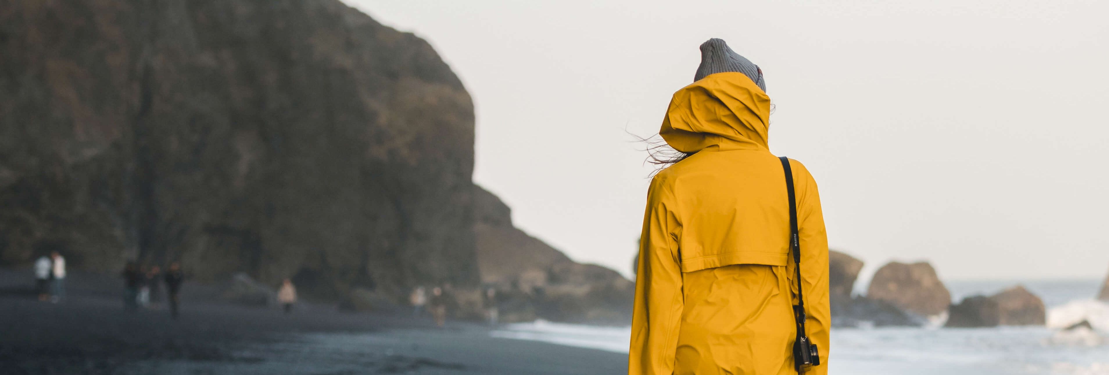 Woman in yellow coat on beach