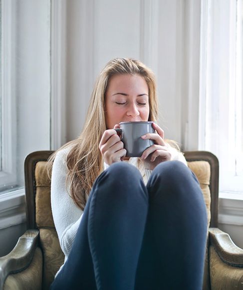 Woman sat on chair drinking tea