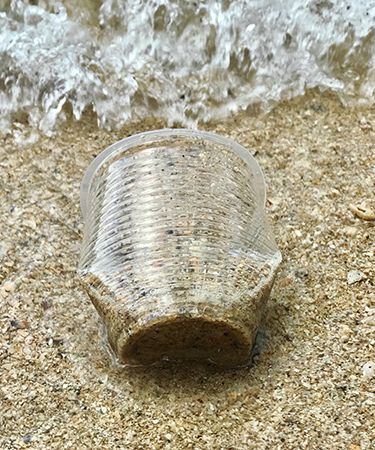 Plastic cup on beach